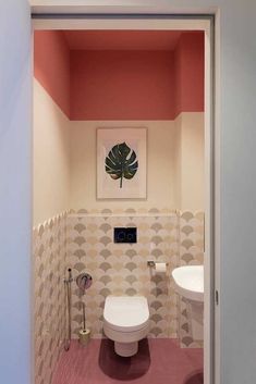 an open door leading to a bathroom with pink and white tiles on the walls, toilet and sink