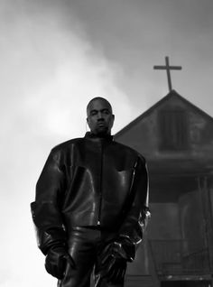 a man standing in front of a building with a cross on it's roof