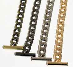 four different types of chains on a white surface with gold, silver and black links