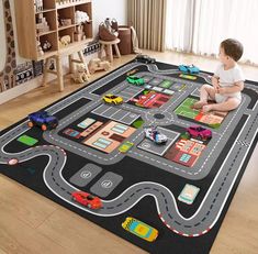 a child is sitting on the floor playing with a road rug