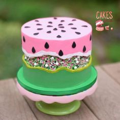 a watermelon cake with sprinkles on top sitting on a green plate