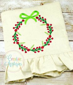 a white cloth with a green bow on it and a red berry wreath in the center