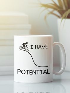 a white coffee mug with the words i have potential and a bicycle rider on it