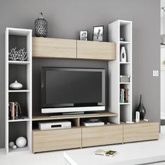 an entertainment center with bookshelves and a television on it's stand in front of a gray wall