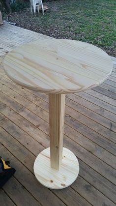 a wooden table sitting on top of a wooden deck next to a pair of shoes