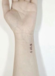 a person's hand with a small tattoo on the middle of their left wrist