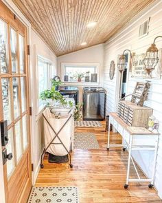 the inside of a home with wood floors and white walls, windows, and wooden ceilinging