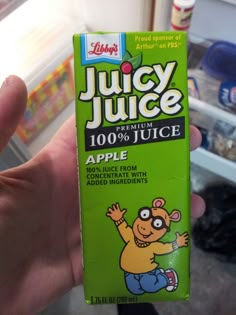 a person holding up a carton of juice