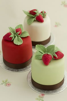 three cakes decorated with strawberries on top of each other