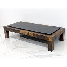 a wooden coffee table sitting on top of a white marble floor next to a wall