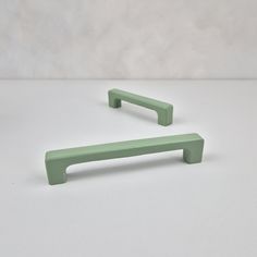 a pair of green handles on a white surface