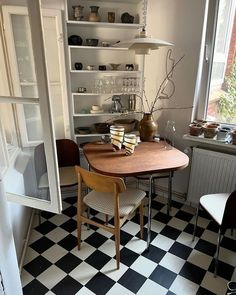 a table and chairs in a room with black and white checkered floor