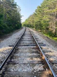 the railroad tracks are lined with rocks and trees