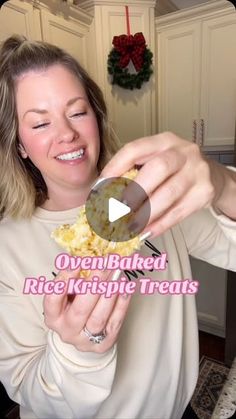 a woman is smiling while eating rice krispy kreme treats