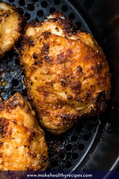 three pieces of chicken cooking in a skillet