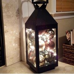 a lantern is lit up with christmas ornaments