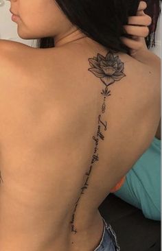 the back of a woman's body with a rose tattoo on her left side