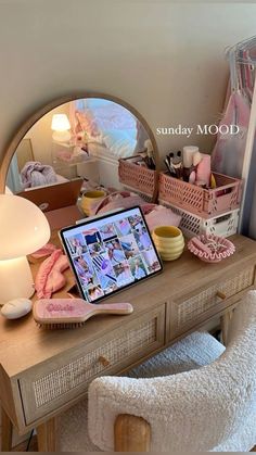 a laptop computer sitting on top of a wooden desk in front of a round mirror