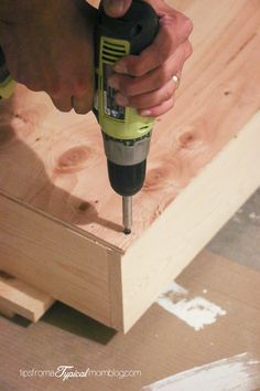 a person using a drill to attach wood planks with a screwdriver on it