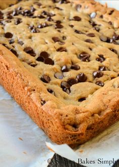 a chocolate chip cookie cake sitting on top of parchment paper