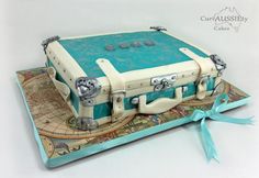 a cake made to look like an old suitcase on top of a map with blue ribbon