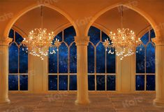 an empty room with large windows and chandeliers