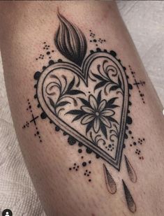 a black and white heart with flowers on it's side, tattoo by the artist