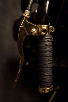 the handlebars and grips of an old motorcycle are gold - plated in detail