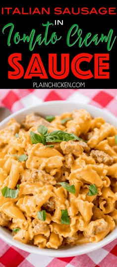 a white bowl filled with tomato cream sauce on top of a red and white checkered table cloth