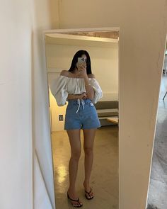 a woman standing in front of a mirror taking a selfie