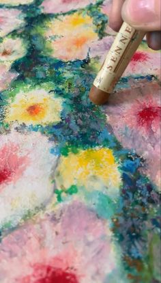 someone is using a marker to paint flowers on the fabric with acrylic ink