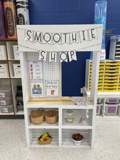 a white shelf with some fruit on it and a sign that says smoothie shop