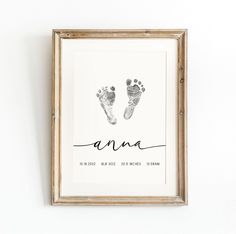 a baby's hand and foot prints are displayed in a frame on the wall