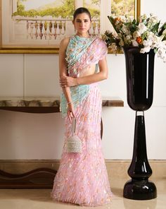 A pastel parade of summery hues, the Zil saree reflects a softcore siren with its structured silhouette, featuring a draped blouse and a pre-stitched mermaid-style skirt. The designer blouse boasts a joyous play of sequins, paired with a pre-draped skirt crafted from tulle fabric and draped using innovative techniques with sequin embellishments. The droplet detailing, crafted from sequins and crystals, adorns the entire silhouette, making it the key feature of this exotic ensemble. A draped blou Spring Party Saree With Unstitched Blouse, Pink Pre-draped Saree For Summer Party, Summer Party Pink Pre-draped Saree, Draped Blouse, Draped Skirt, Mermaid Style, Designer Blouse, Style Skirt, Tulle Fabric