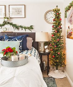 a bedroom decorated for the holidays with christmas decorations on the bed and tree in the corner