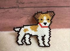 a beaded dog brooch sitting on top of a white rug next to a wooden wall