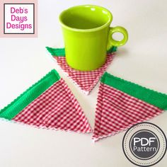 a green cup sitting on top of a red and white checkered napkin