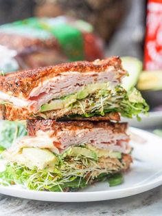 two sandwiches stacked on top of each other with lettuce and meat in the middle