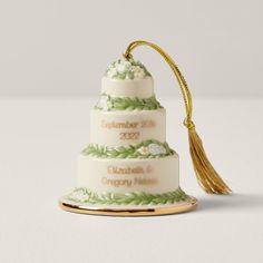 a three tiered cake ornament with a tassel