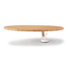 a round wooden table with white legs and an ironing board attached to the top