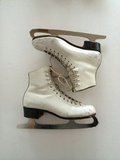 a pair of ice skates sitting on top of a white wall