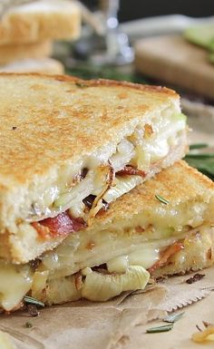 a grilled cheese sandwich sitting on top of a piece of paper next to some bread