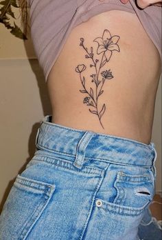 a woman's stomach with a flower tattoo on it