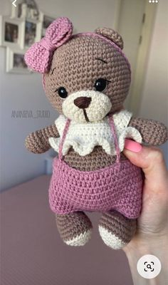 a small crocheted teddy bear with a pink bow