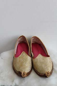 Vintage Indian theme inspired slippers. The slippers/flats are a gold tone brocade design. The inside is lined in a bright pink fabric. The toe is curved up and has a tassel detail. The shoes are in good condition.Size: 7.5Inside Length: 9.5" | Inside Width: 3.25" | Outside Heel Length: .75" | Inside Heel Length: .25"Unless otherwise stated all vintage items are used and may have minor to moderate wear or discoloration considering the age of the item. Most items have been hand washed, spot clean Indian Theme, Womens Wedding Shoes, Vintage Indian, House Shoes, Flat Espadrille, Pink Fabric, Bright Pink, Boho Wedding, Wedding Shoes