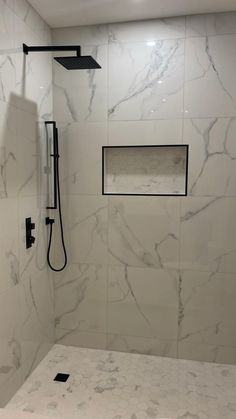 a bathroom with white marble walls and flooring, including a walk - in shower