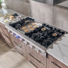 a stove top oven sitting in a kitchen next to a counter with food on it