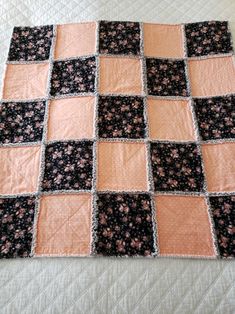 a black and pink patchwork quilt on a bed