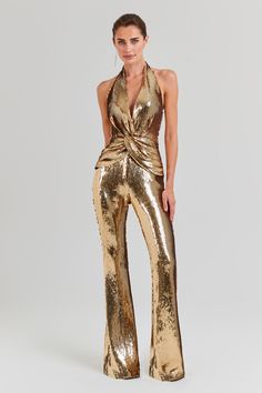 Tianna Gold Jumpsuit Women's Clothing > Jumpsuits. DESCRIPTION &  FEATURES  Feel a million dollars when dressed in the TIANNA Gold Jumpsuit,  a luxurious high-shine design. This halter neck jumpsuit is adorned with exclusively designed gold sequins and features fixed knot twist detailing to the front, forming elegant pleats to create a sculpting finish. This figure-hugging jumpsuit is finished with flared trousers, a concealed zip to the back, and is fully lined.   - Exclusively designed high-sh Gold Sequin Jumpsuit, Sequin Pattern, Halter Neck Jumpsuit, Sequin Halter, Flare Jumpsuit, Bodycon Jumpsuit, Halter Jumpsuit