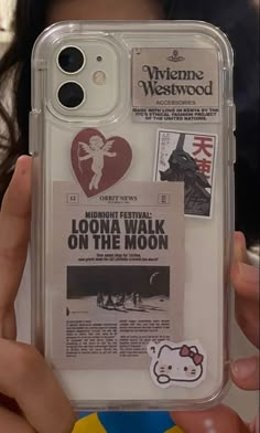 someone is holding up their phone case to show the back cover with stickers on it